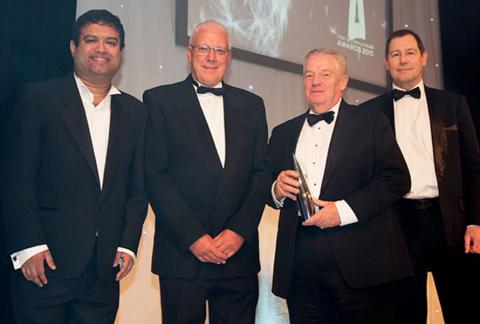 Four men in suits receiving award