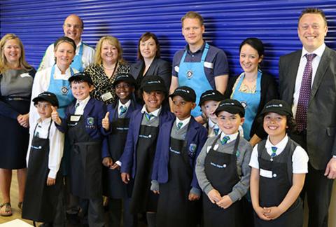 Group of adults and children in kitchen attire