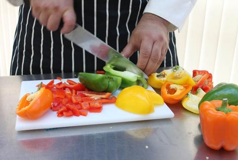close-up of hands cutting bell peppers