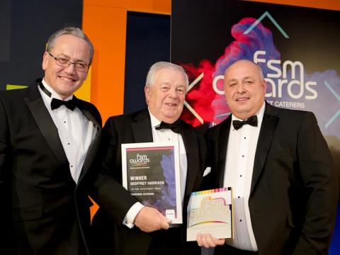 Three men on stage receiving award