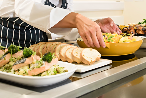 Close-up of hands arranging food platters