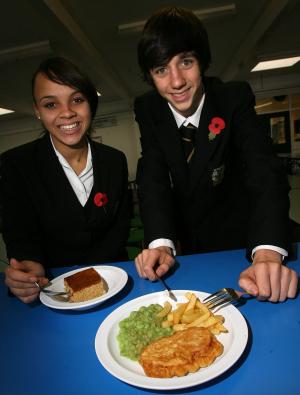 Two students smiling with plates of food
