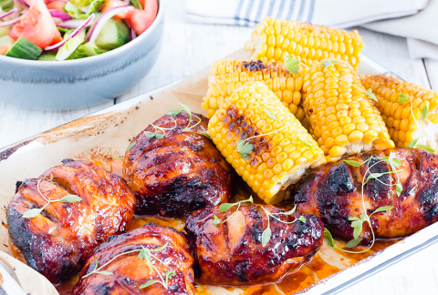 a platter of BBQ chicken and corn