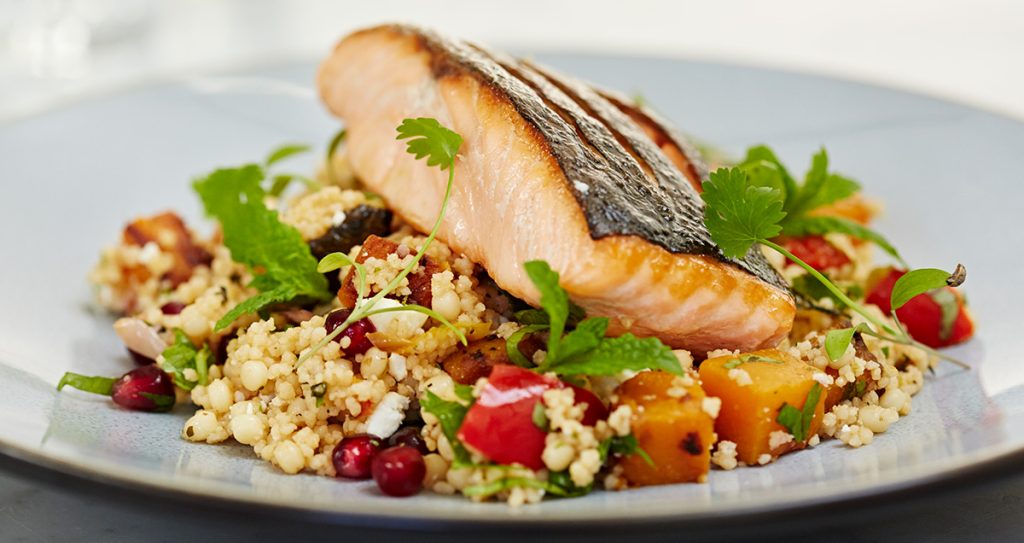 a plate of couscous with butternut squash and harissa-crusted salmon