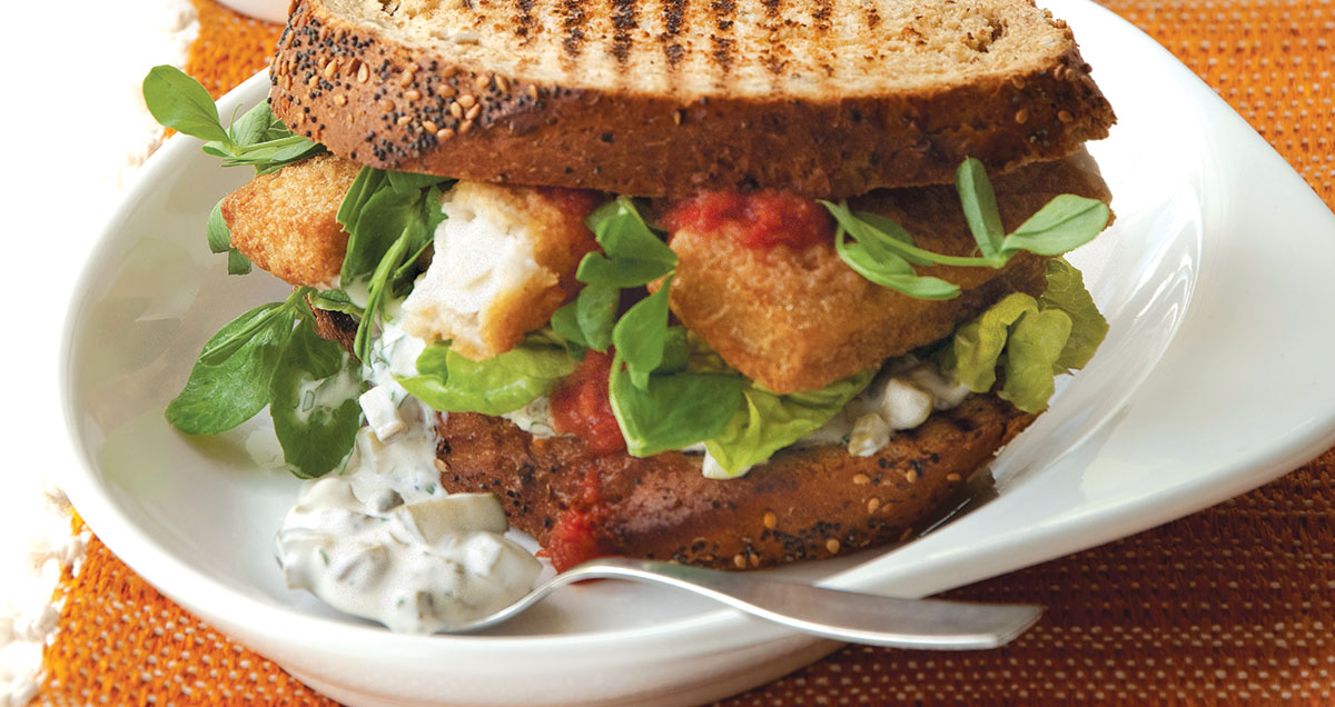 A close up of Fish finger sandwich with tartare sauce