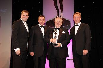 Four men in suits receiving award