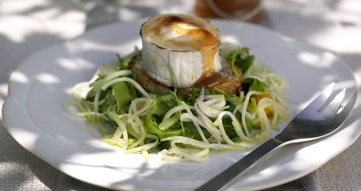 a plate of Grilled goat's cheese on kohlrabi slaw with Manuka honey