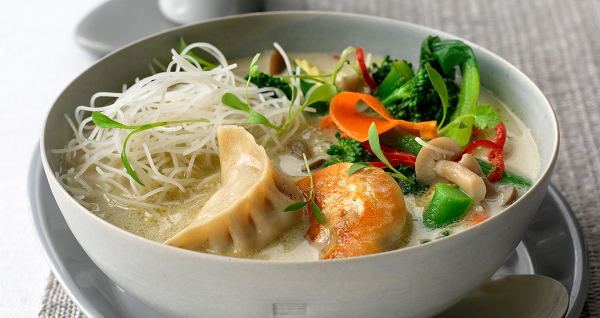 A bowl of noodle soup with dumplings