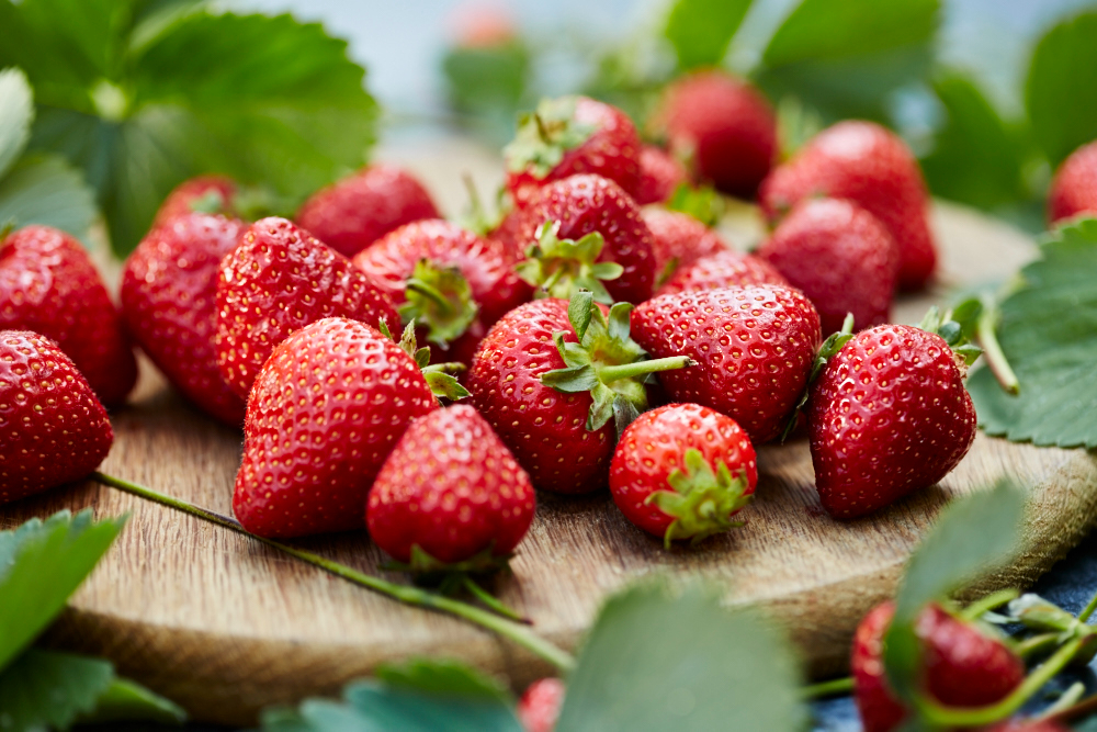 a bunch of strawberries on wooden board